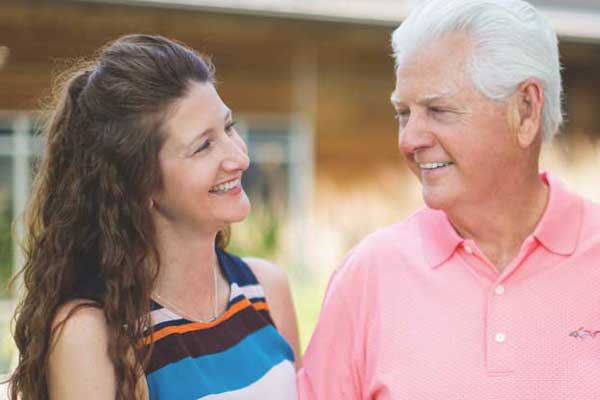 A daughter visits her senior father outside of the house